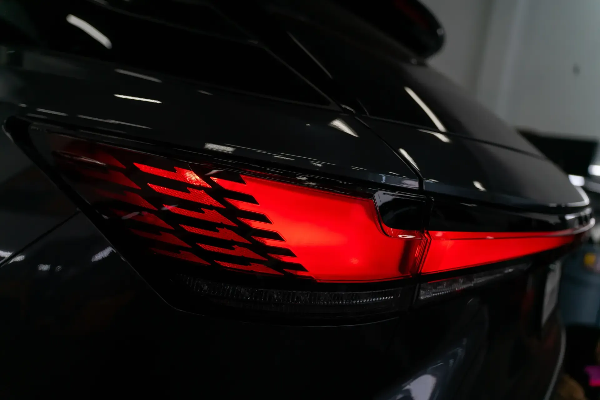 Glossy black vehicle finish under the lighting in the PPF Pros shop
